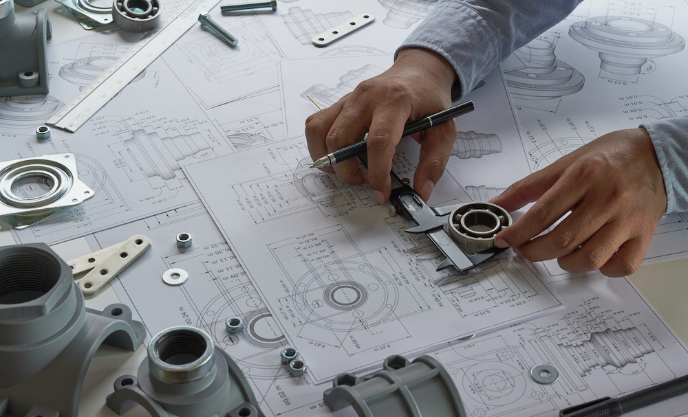 Engineer technician designing drawings mechanical parts engineering Enginemanufacturing factory Industry Industrial work project blueprints measuring bearings caliper tools